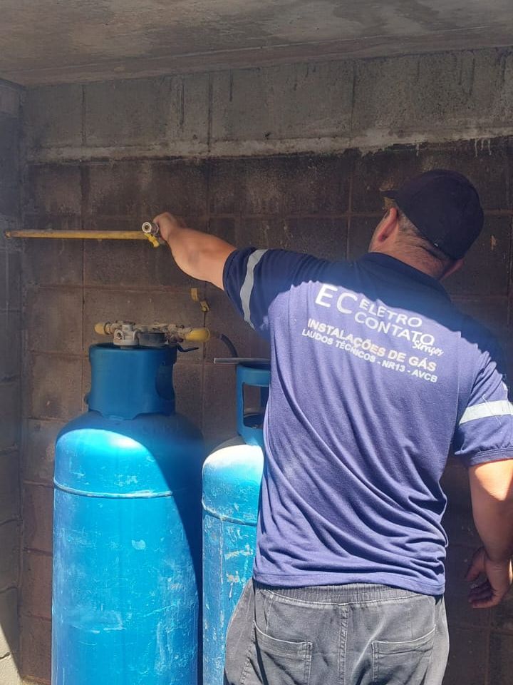 Técnico da Eletro Contato ligando a tubulação aos cilindros de GLP dentro do abrigo