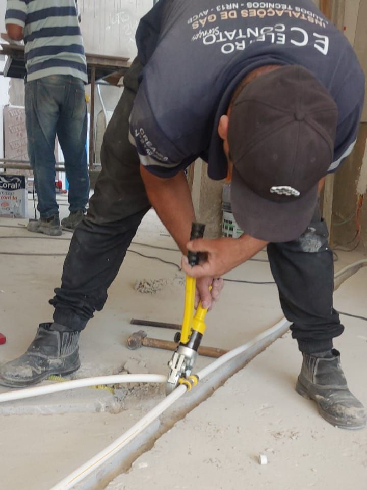 Técnico da Eletro Contato crimpando tubulação de gás multicamada PEX no contrapiso de uma obra